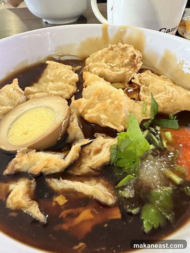 Bowl of Noodles with Fried Items and Egg