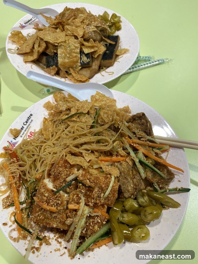Two plates of food at a hawker centre
