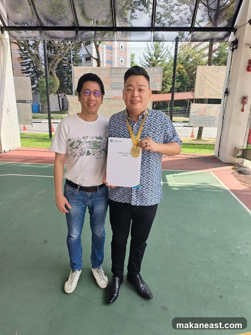 Two men posing with a certificate and medal