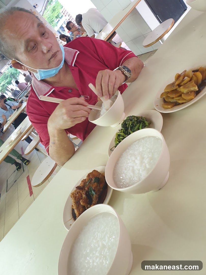 Man eating congee with side dishes