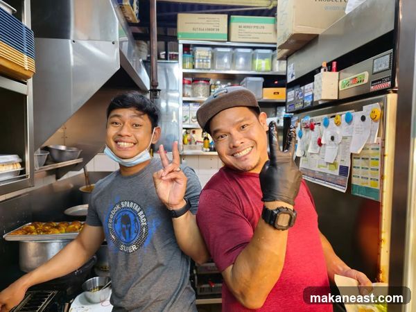 Two men posing in a kitchen