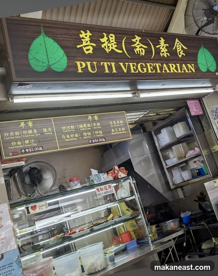 A wooden sign with green leaves and Chinese characters reads "PU TI VEGETARIAN". Below the sign is a menu board with various food items and prices. The storefront features a display case with food items and a self-service sign.