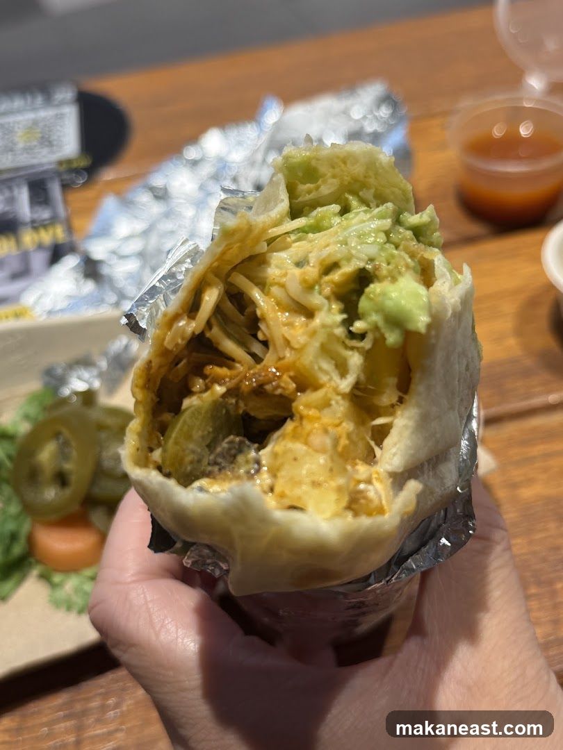 Close-up of a burrito with avocado and jalapeños