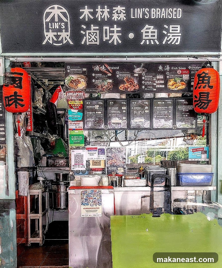 A food stall with a black facade displaying menus and signage. Red lanterns hang on either side. The stall offers braised dishes and fish soup. Various delivery service logos are visible, including Deliveroo, Go Digital, and GrabFood. A QR code for payment is also displayed.