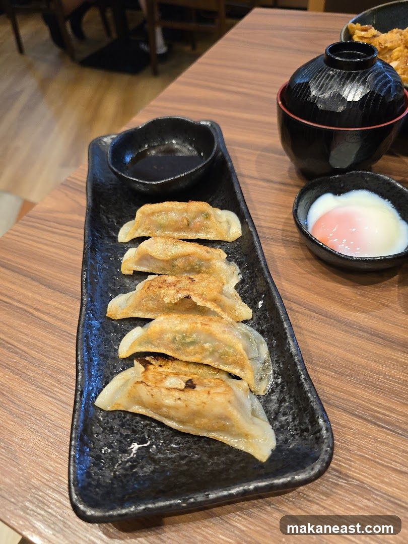 Pan-fried dumplings with dipping sauce and a soft-boiled egg