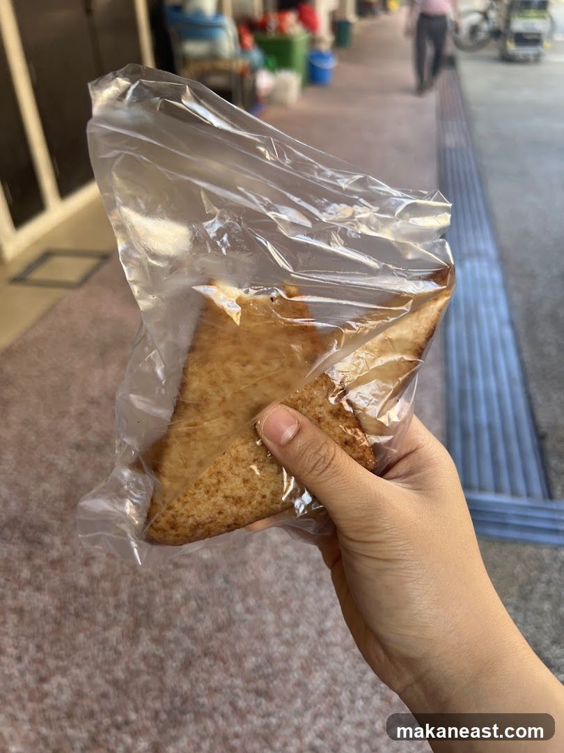 Hand Holding Pastry in Plastic Bag