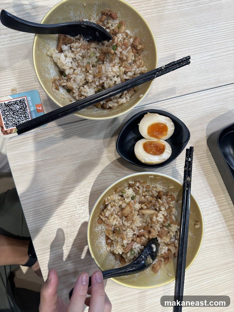 Two bowls of rice with meat and a side of egg