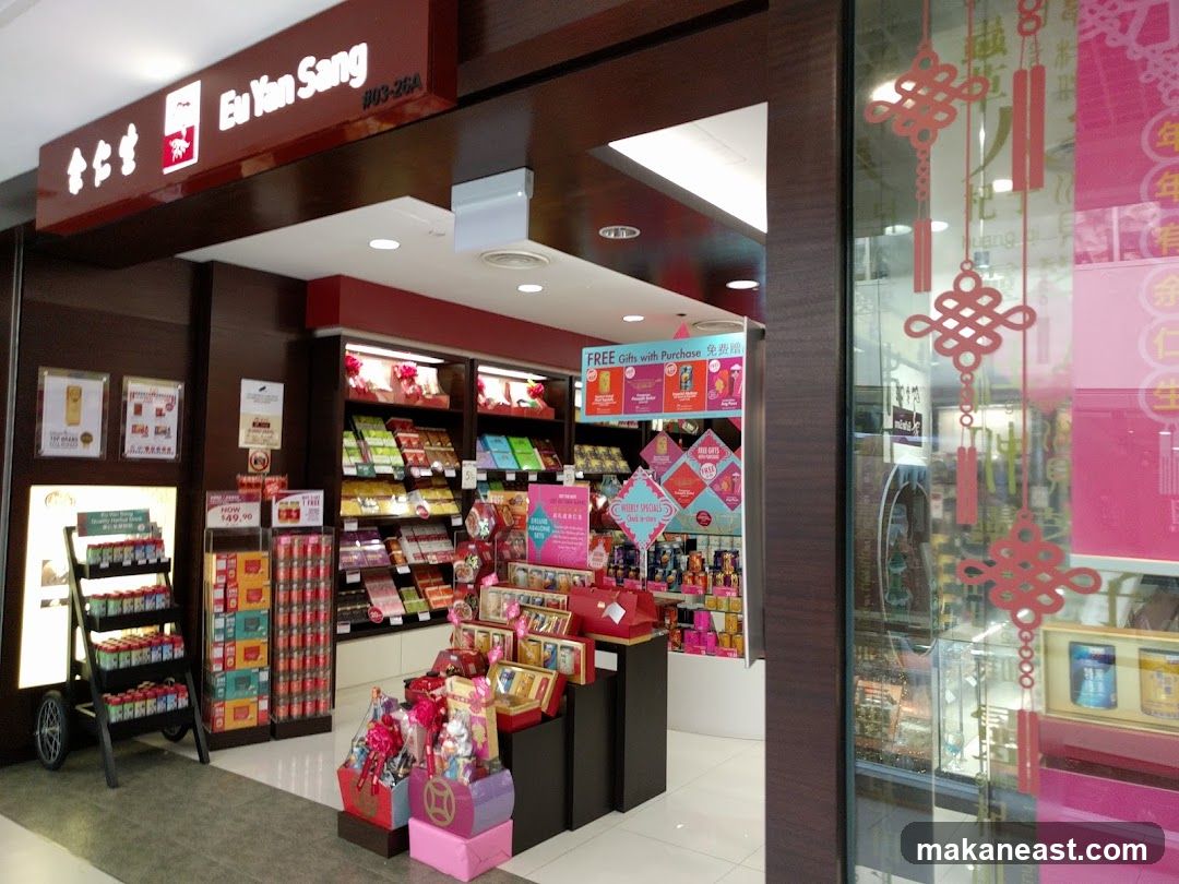 The exterior of a Eu Yan Sang shop. The shop has a dark wood facade with a prominent sign displaying the brand name. Inside, shelves are stocked with various products, including gift baskets and packaged items. Promotional displays advertise "FREE Gifts with Purchase" and "WEEKLY SPECIALS". The shop's entrance is visible, with merchandise displayed both inside and near the doorway.