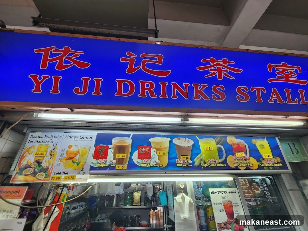 The exterior of a drinks stall with a large blue sign displaying the name 'YI JI DRINKS STALL' in red Chinese characters and English. Below the main sign is a menu board showcasing various drinks with images and prices. The menu includes Passion Fruit Juice, Honey Lemon, Kopi, Milk Tea, Milo, Sugar Cane Drinks, Homemade Ice Lemon Tea, and Calamansi Drinks. A smaller sign for Hawthorn Juice is also visible.