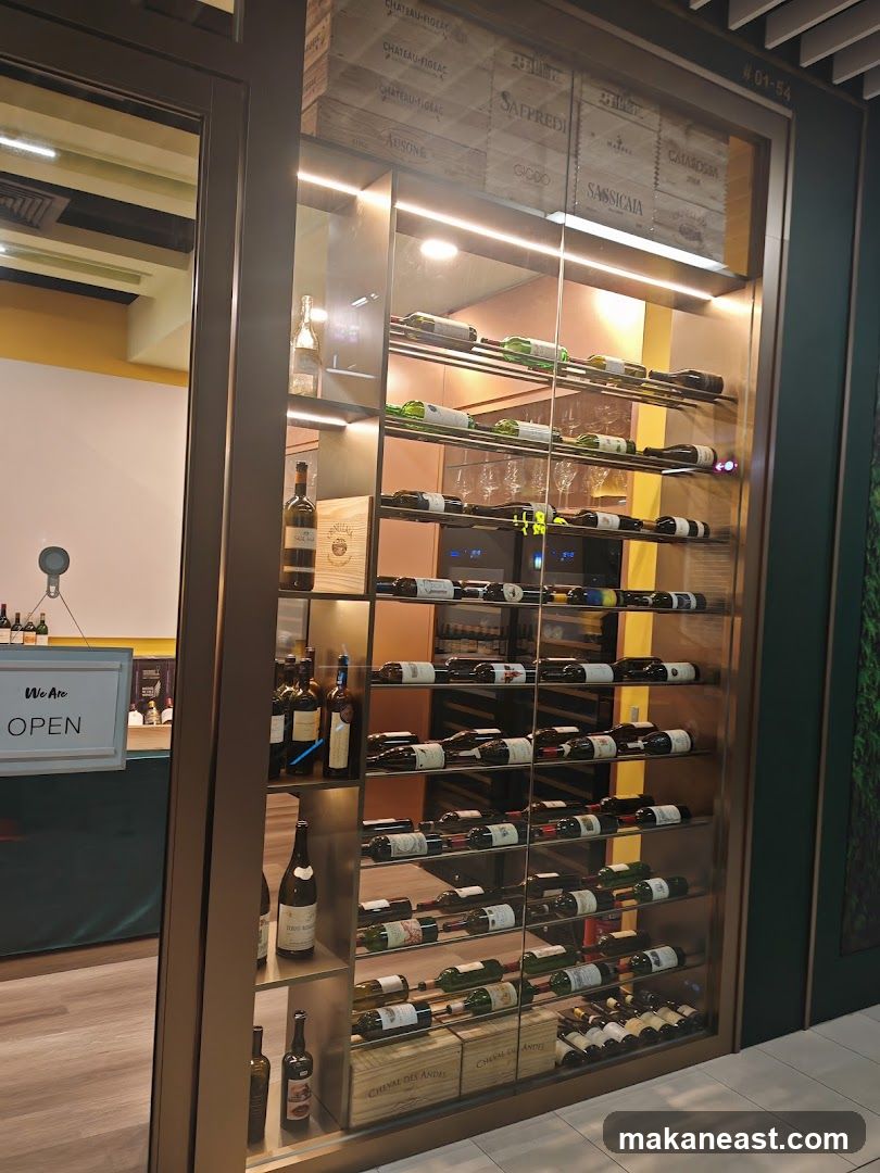 A glass-fronted wine display cabinet is visible, filled with numerous bottles of wine. Wooden crates with wine labels are stacked at the bottom. A sign that reads "We Are OPEN" is visible to the left. The display is illuminated by interior lighting.