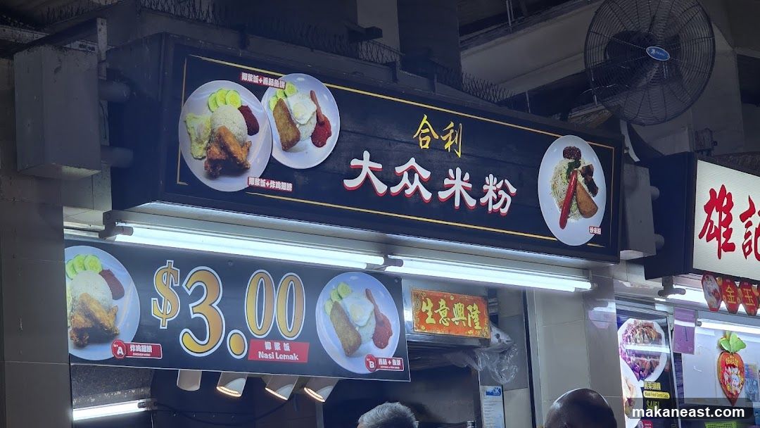 A food stall sign with images of Nasi Lemak and other dishes. The sign displays prices and dish names in Chinese and English.