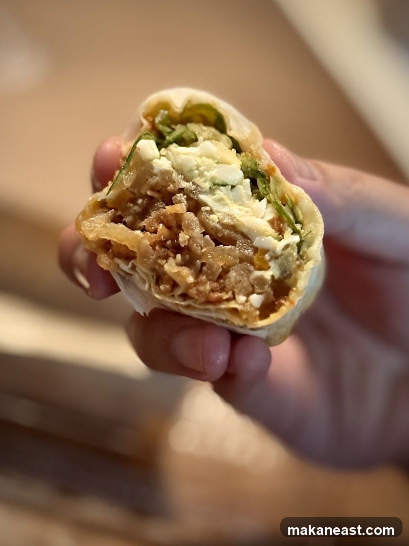 Close-up of a hand holding a cut-open burrito