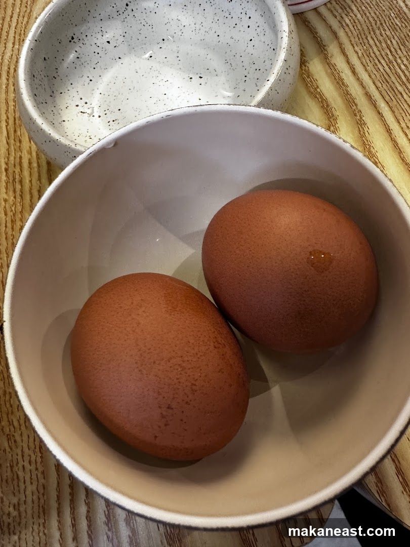 Two brown eggs in a bowl