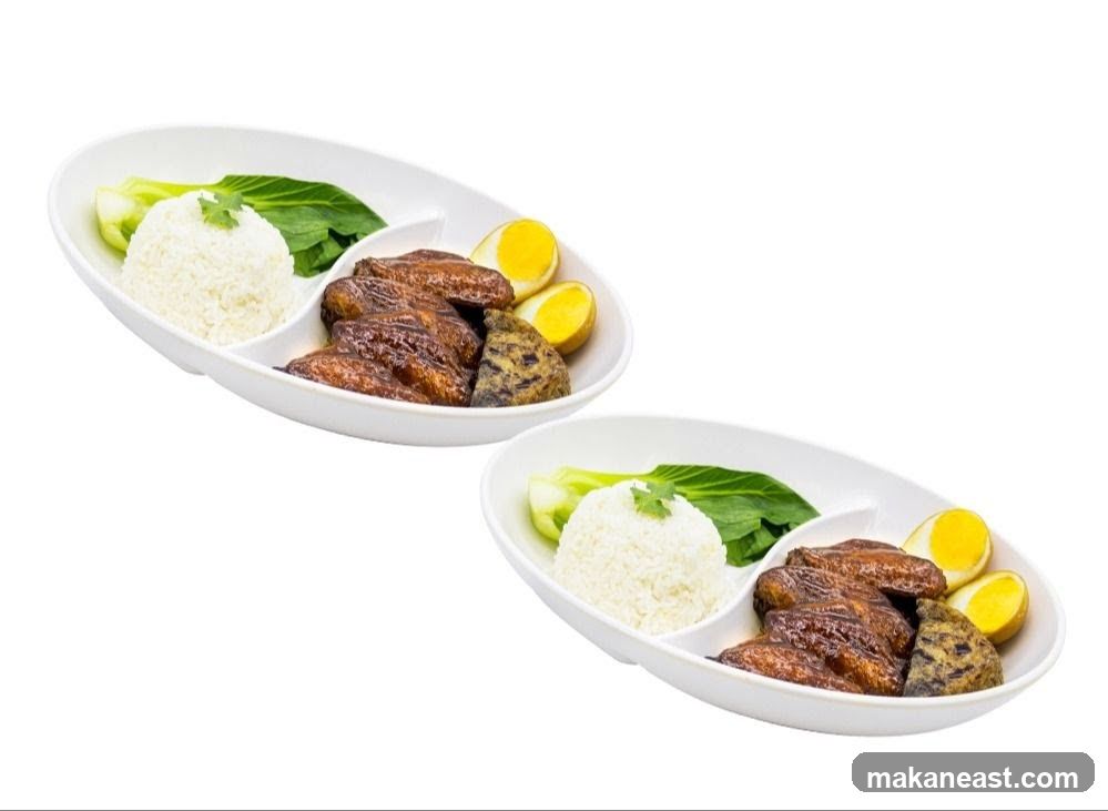Two plates of braised chicken wings with rice and vegetables