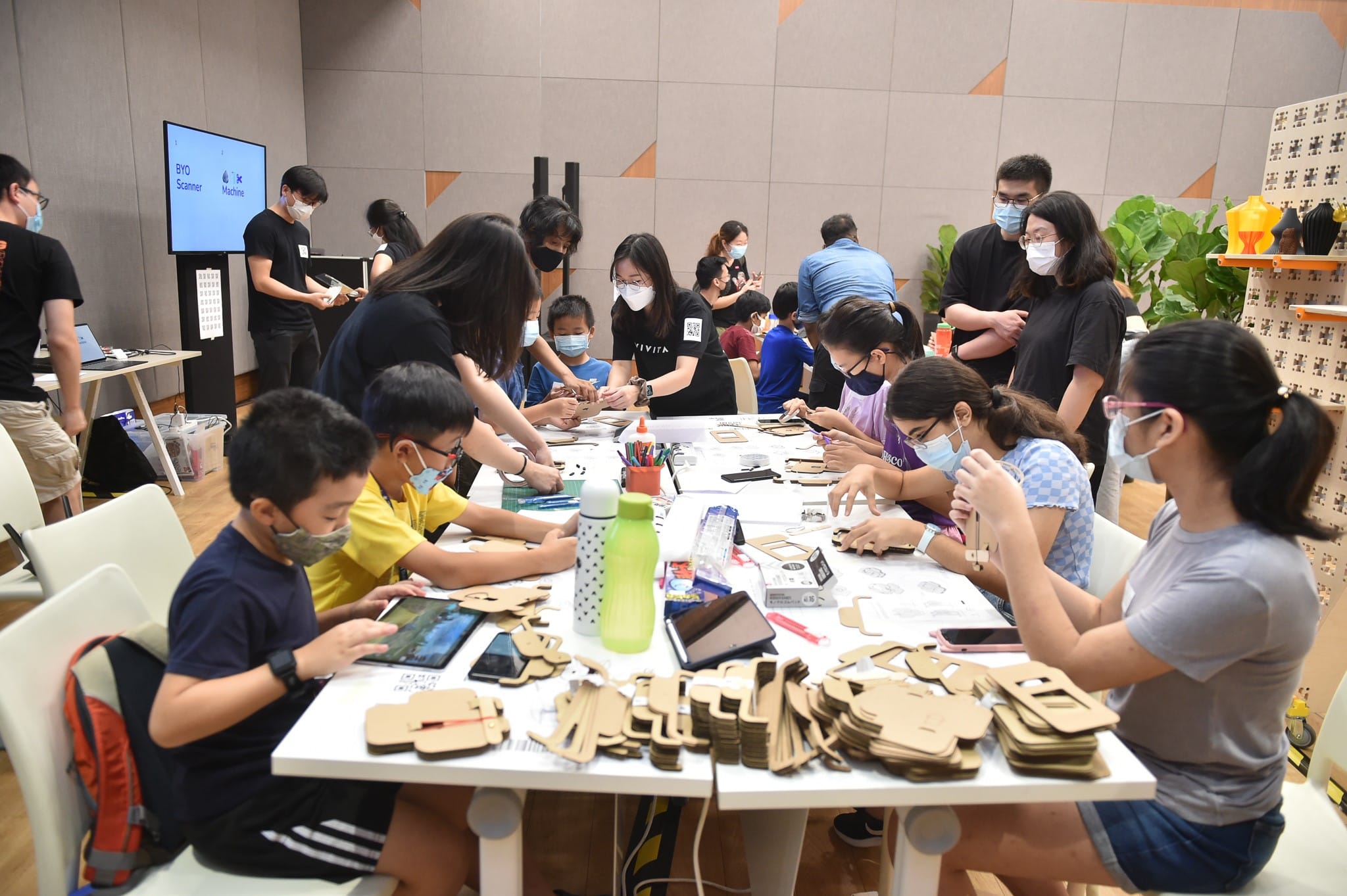 Families at a hands-on workshop table inside Heartbeat@Bedok, People's Association photo of a previous civic digital session