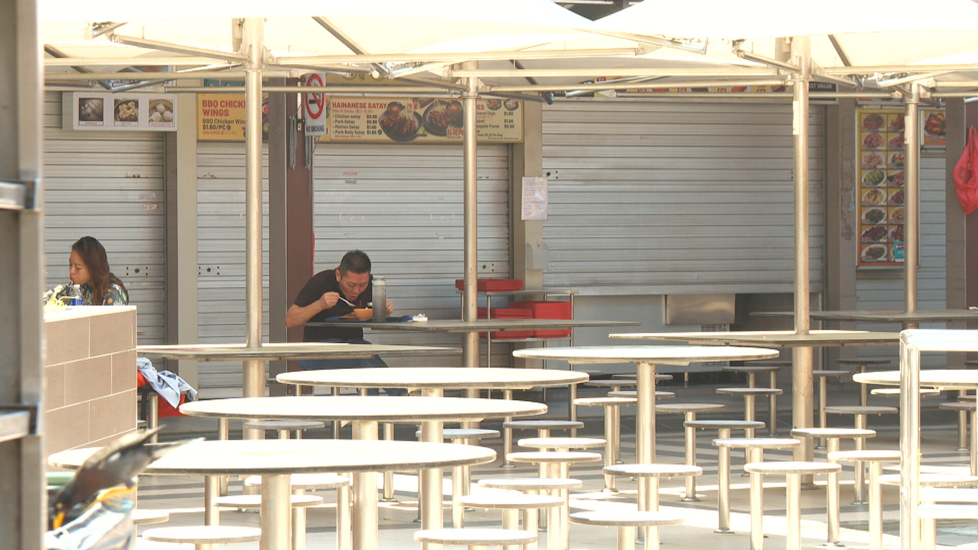 Empty round tables and shuttered BBQ stalls at East Coast Lagoon Food Village